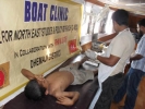 An injured child being attended to, at the Dhemaji Boat Clinc by Medical Officers Dr Safiqul Islam(back to camera) and Dr Hafizur Rahman(extreme right)