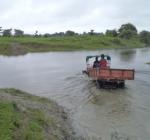 The tractor crosses a flooded channel with the team onboard to a camp at Madhupur and Chilling