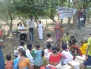 Tapan Bora(standing middle), Distict community organizer, Lakhimpur introducing the concept of the Boat Clinic to the local community at the Kankan sapori, gathered for the inaugural camp on 16 march 2009. Seated  next to him is Dr Dipankar Thakuria, Medical officer, Lakhimpur Boat Clinic.