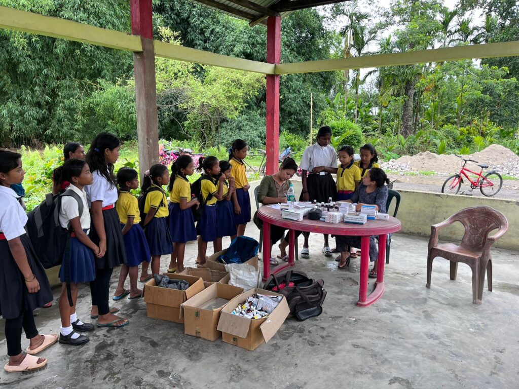 School children wait patiently for their turn at a health camp conducted by upper Assam’s Dhemaji Boat Clinic at Nalbari island village in June 2023